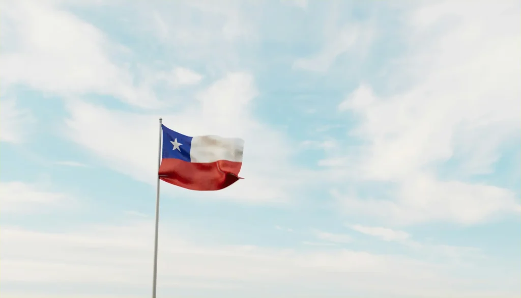 Texas flag flying against bright blue, cloudy sky