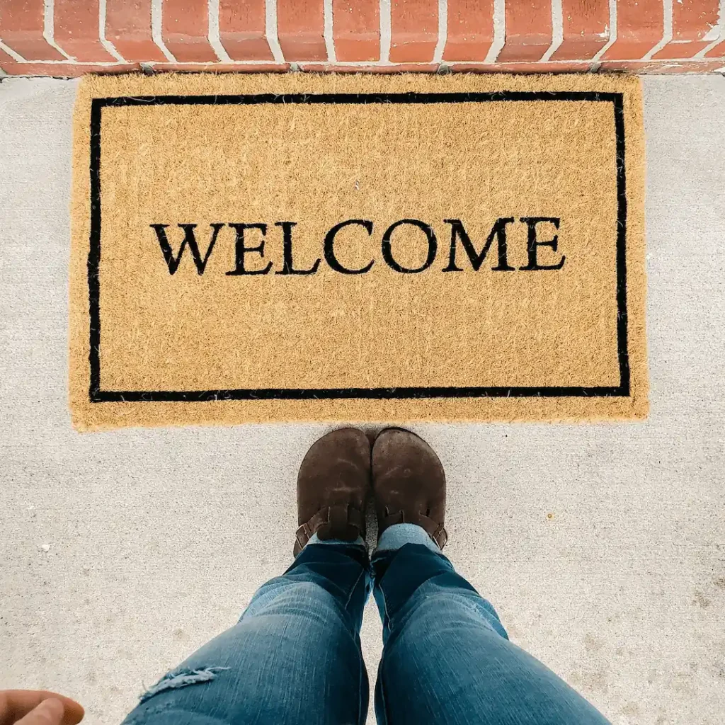 Feet standing in front of a welcome mat